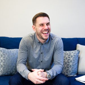 A Chipper User sits happily on his sofa at home.